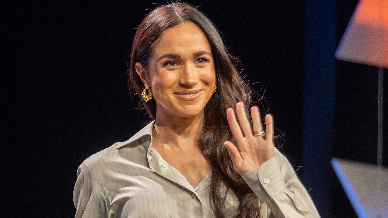 A close-up of Meghan Markle waving.