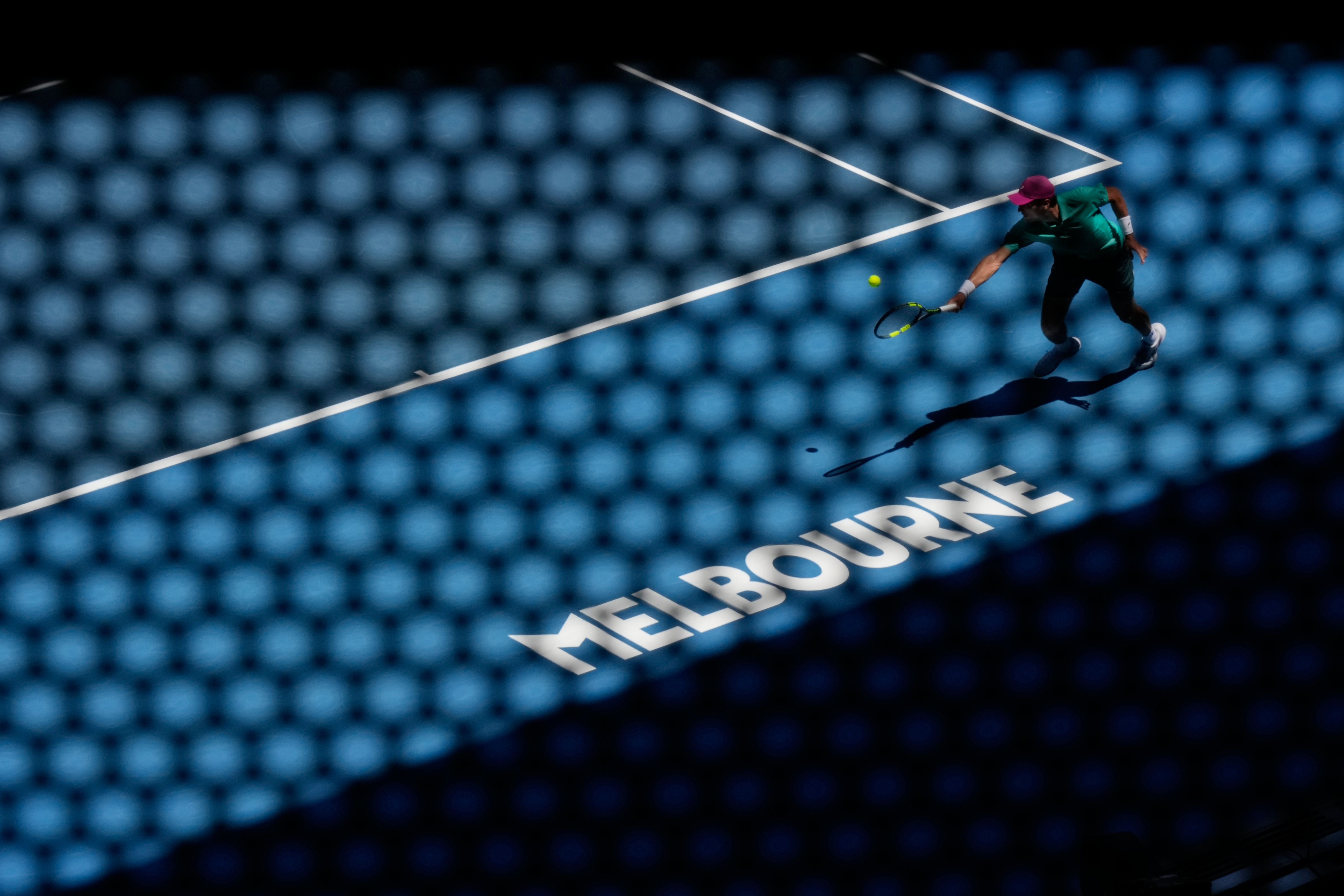 Raphael Collignon of Belgium plays a backhand return to Lorenzo Musetti of Italy during their first round match at the Australian Open tennis championship in Melbourne, Australia, Tuesday, Jan. 20, 2026. (AP Photo/Aaron Favila)