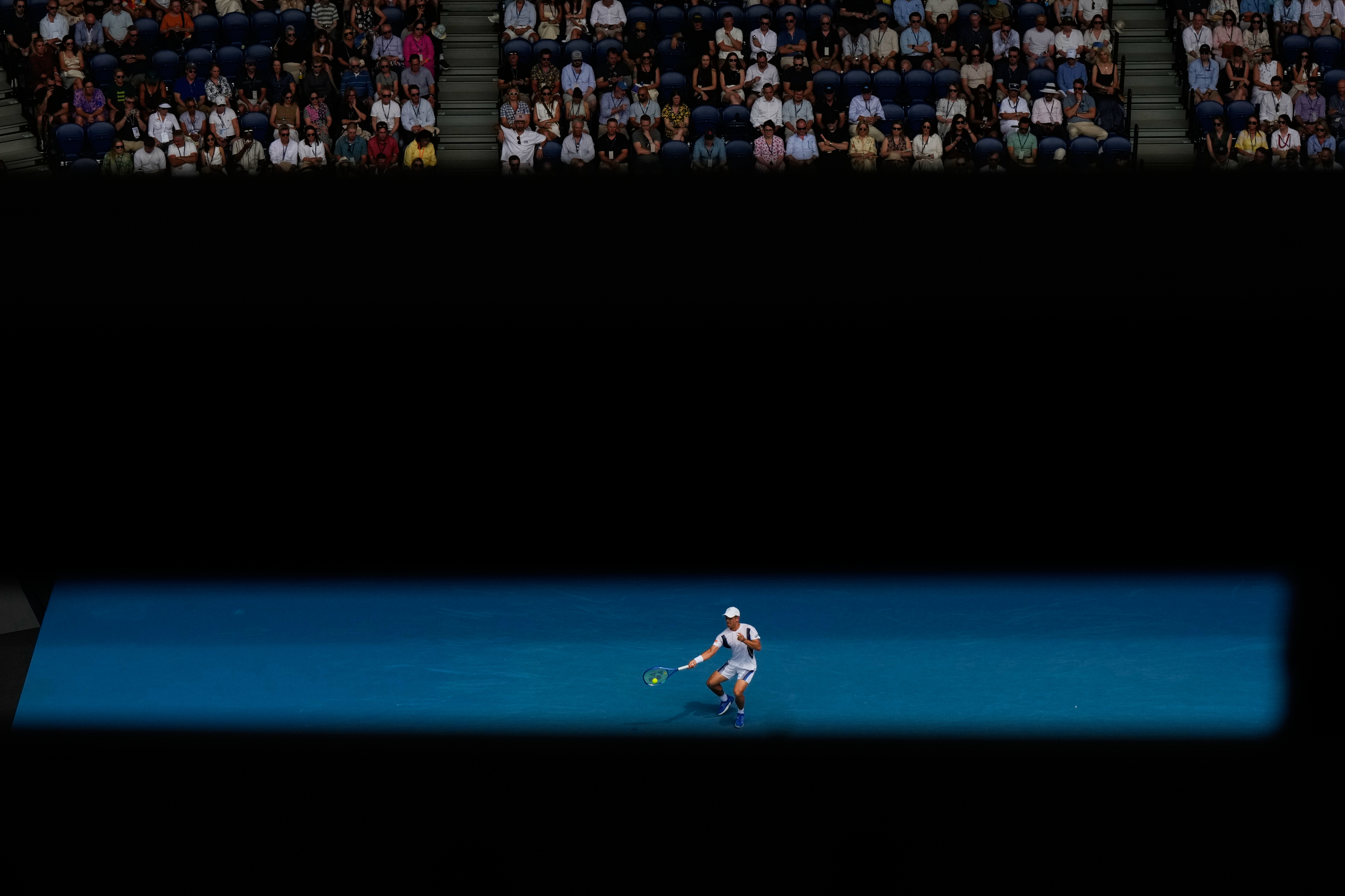 Mackenzie McDonald of the U.S. plays a forehand return to Alex de Minaur of Australia during their first round match at the Australian Open tennis championship in Melbourne, Australia, Monday, Jan. 19, 2026. (AP Photo/Aaron Favila)