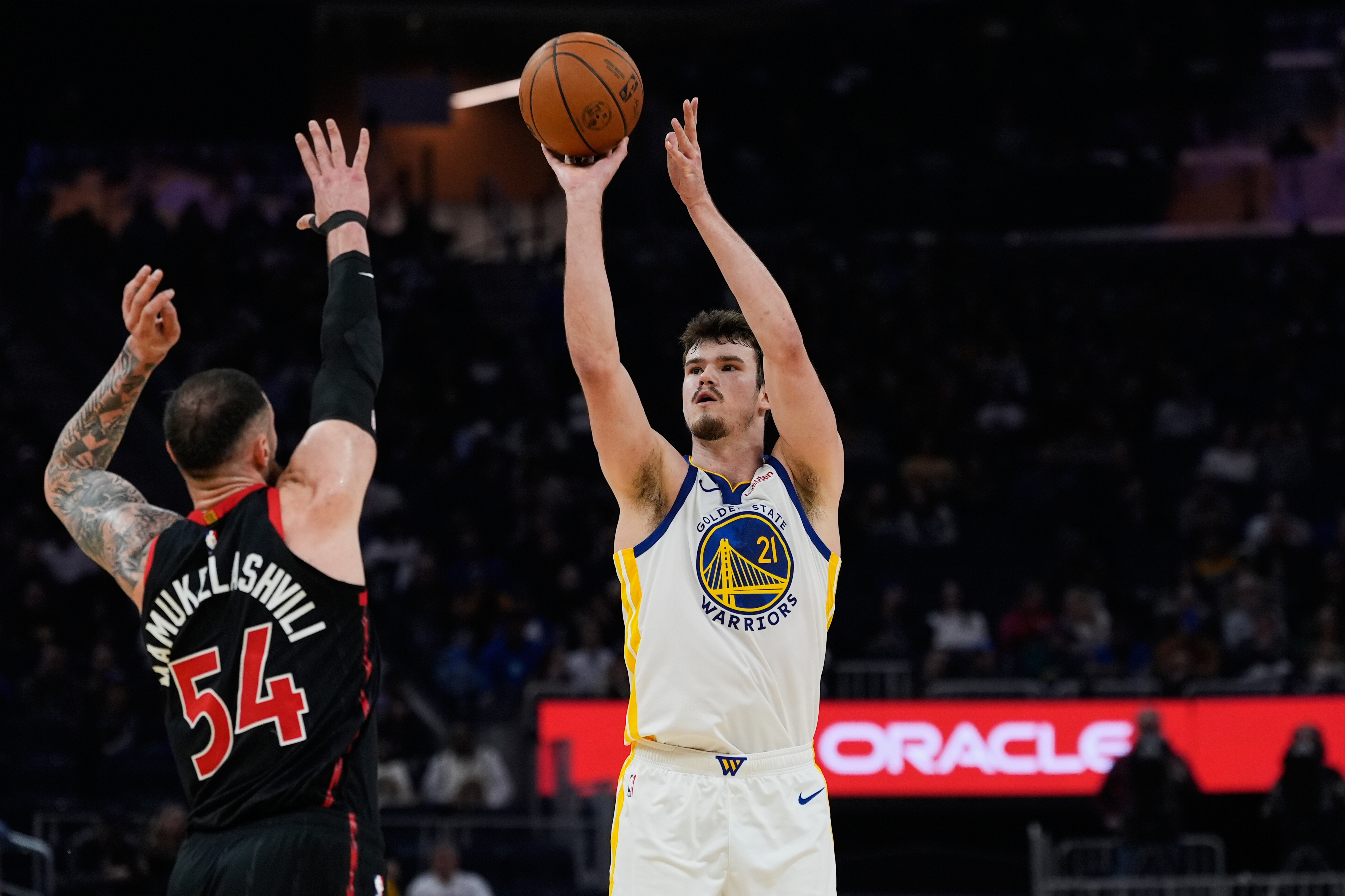 Golden State Warriors center Quinten Post (21) shoots a 3-point basket over Toronto Raptors forward Sandro Mamukelashvili (54) during the first half of an NBA basketball game, Tuesday, Jan. 20, 2026, in San Francisco. (AP Photo/Godofredo A. Vásquez)