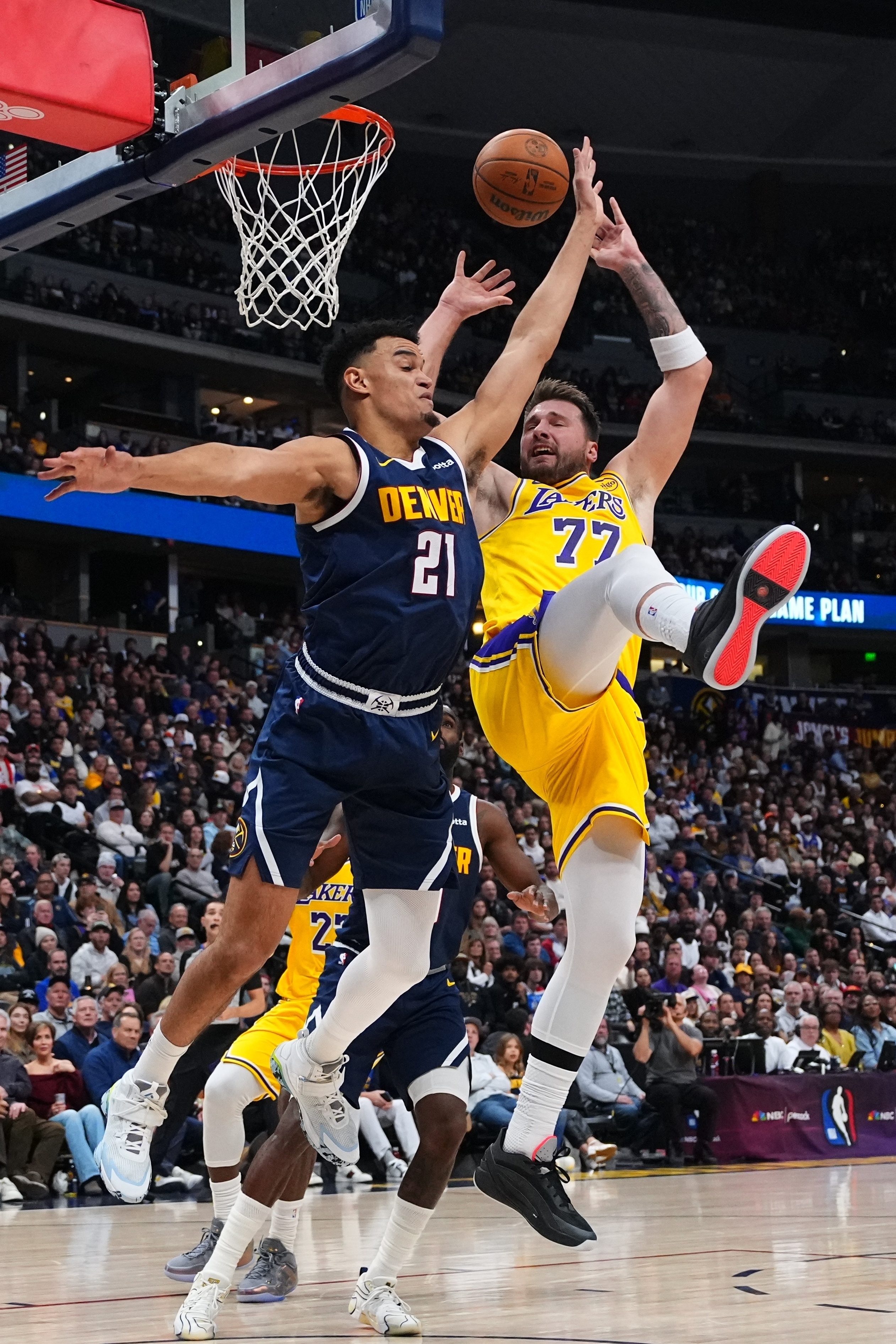 Denver Nuggets forward Spencer Jones (21) fouls Los Angeles Lakers forward Luka Dončić (77) during the first half of an NBA basketball game Tuesday, Jan. 20, 2026, in Denver. (AP Photo/Jack Dempsey)