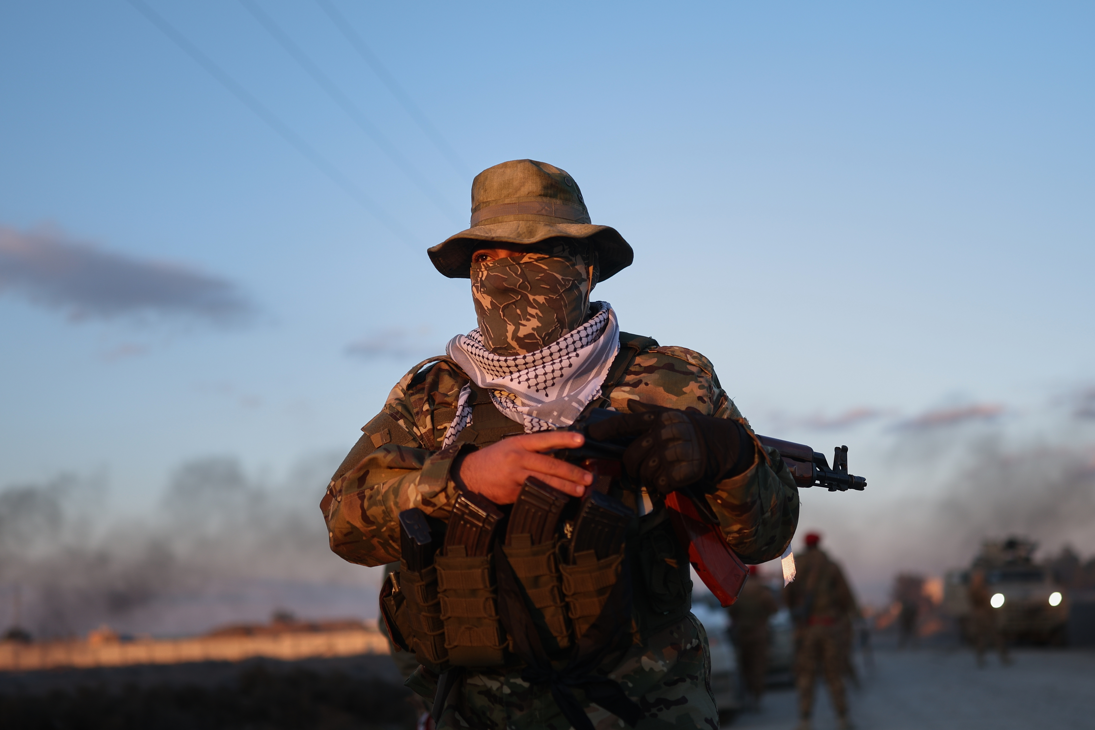 A Syrian government fighter stands guard outside Al-Aqtan prison on the outskirts of Raqqa, northeastern Syria, Monday, Jan. 19, 2026, as negotiations are underway with the Kurdish-led Syrian Democratic Forces over a withdrawal from the prison. (AP Photo/Ghaith Alsayed)