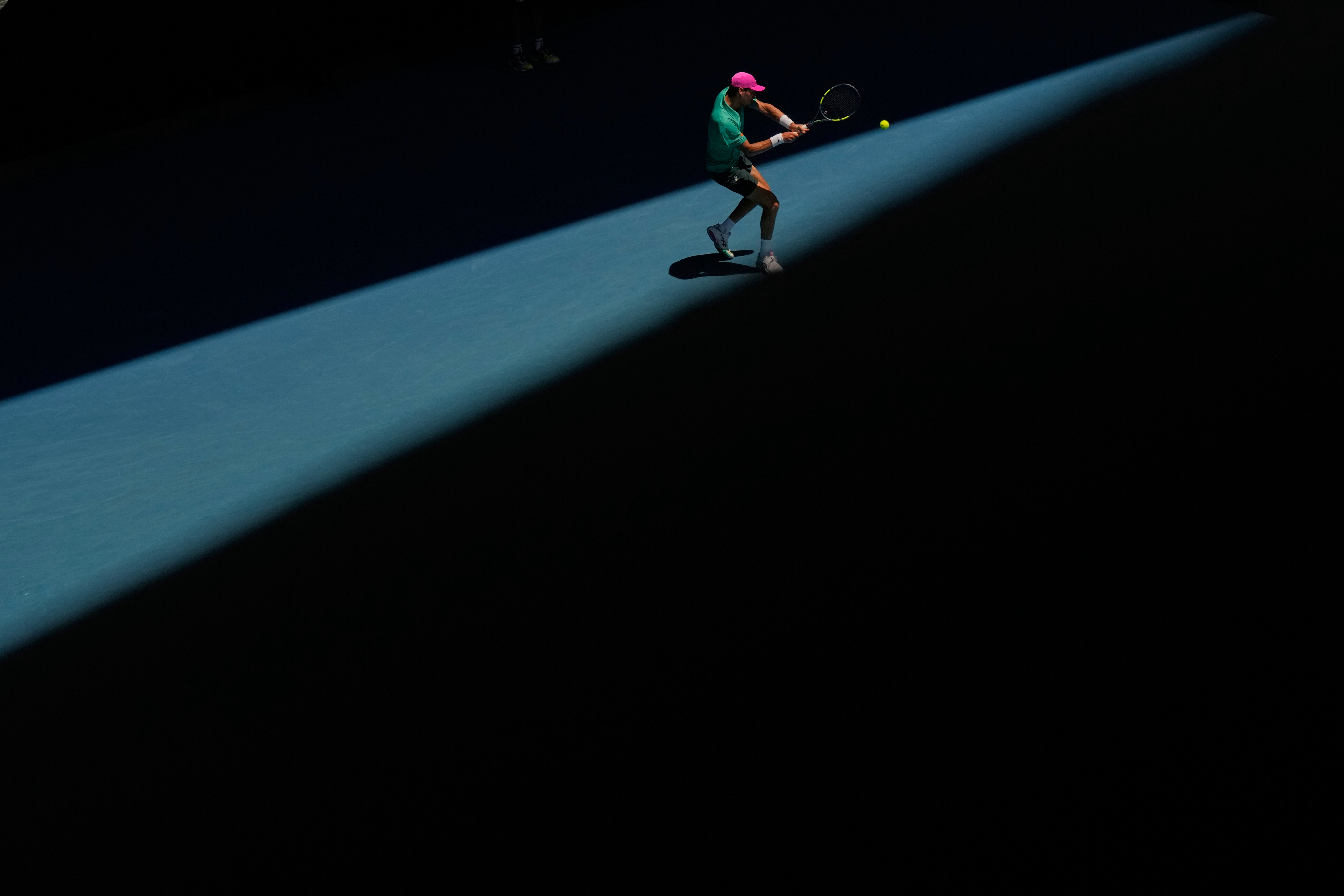 Raphael Collignon of Belgium plays a backhand return to Lorenzo Musetti of Italy during their first round match at the Australian Open tennis championship in Melbourne, Australia, Tuesday, Jan. 20, 2026. (AP Photo/Aaron Favila)