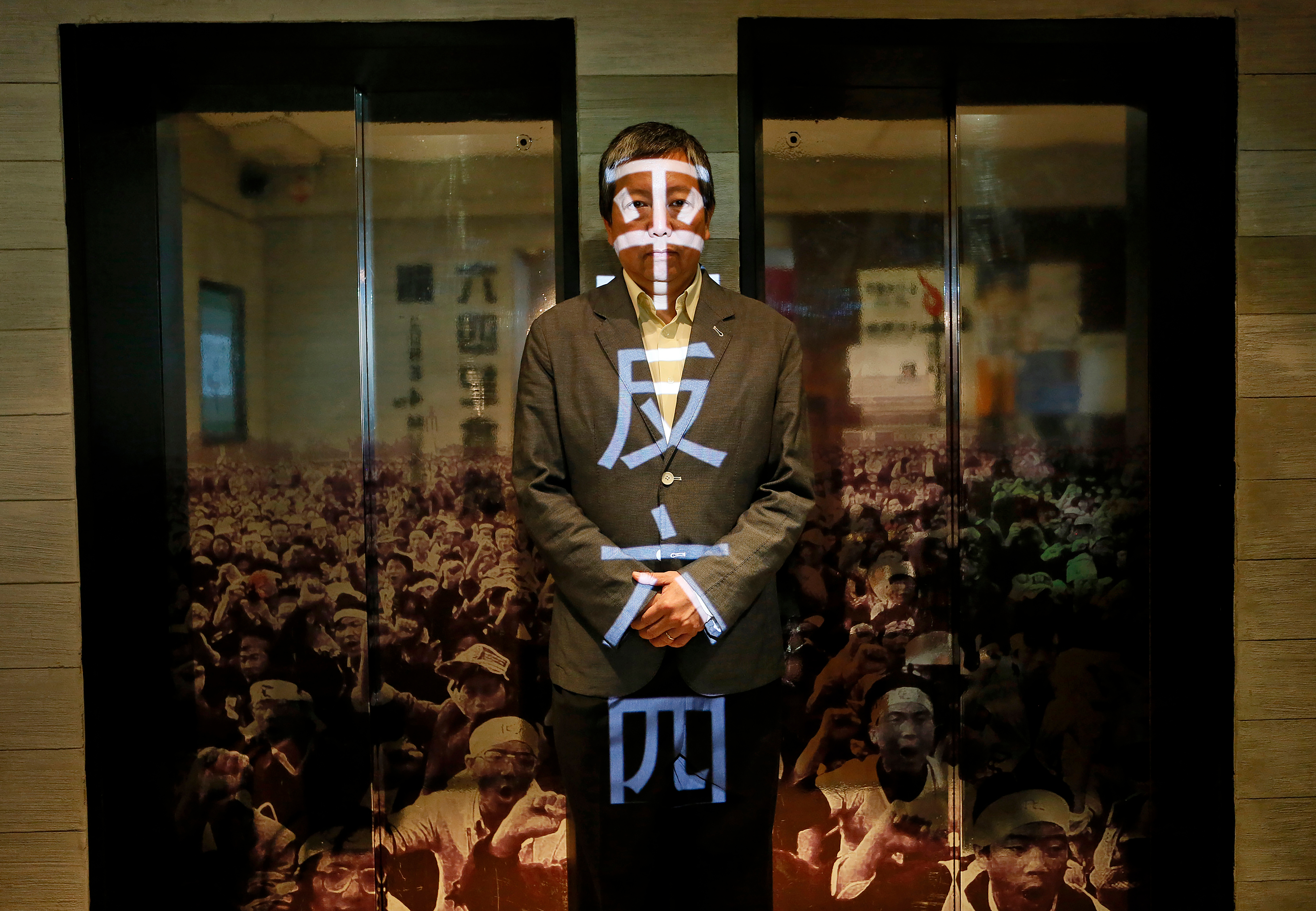 FILE - Lee Cheuk Yan poses at the June 4 Museum his pro-democracy group operates May 28, 2014, in Hong Kong, with the words 