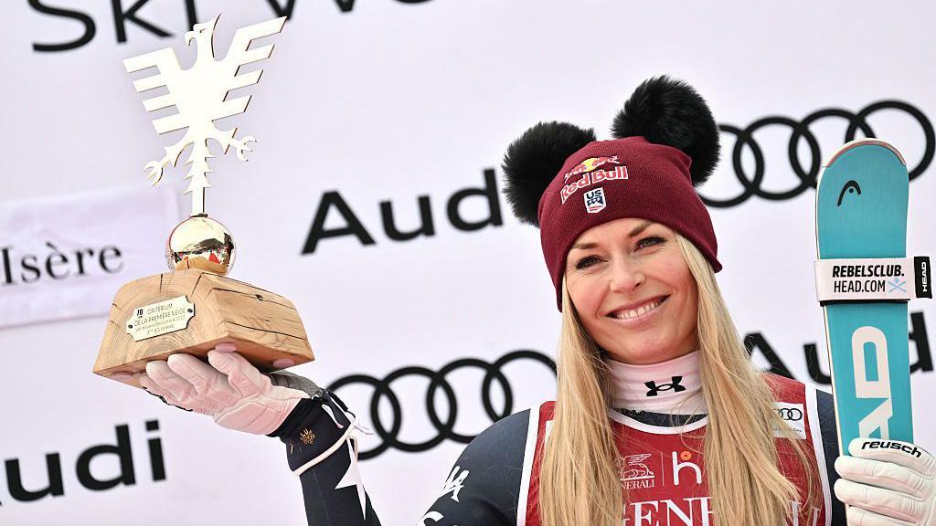 Third-placed Lindsey Vonn holds her trophy as she celebrates on the podium