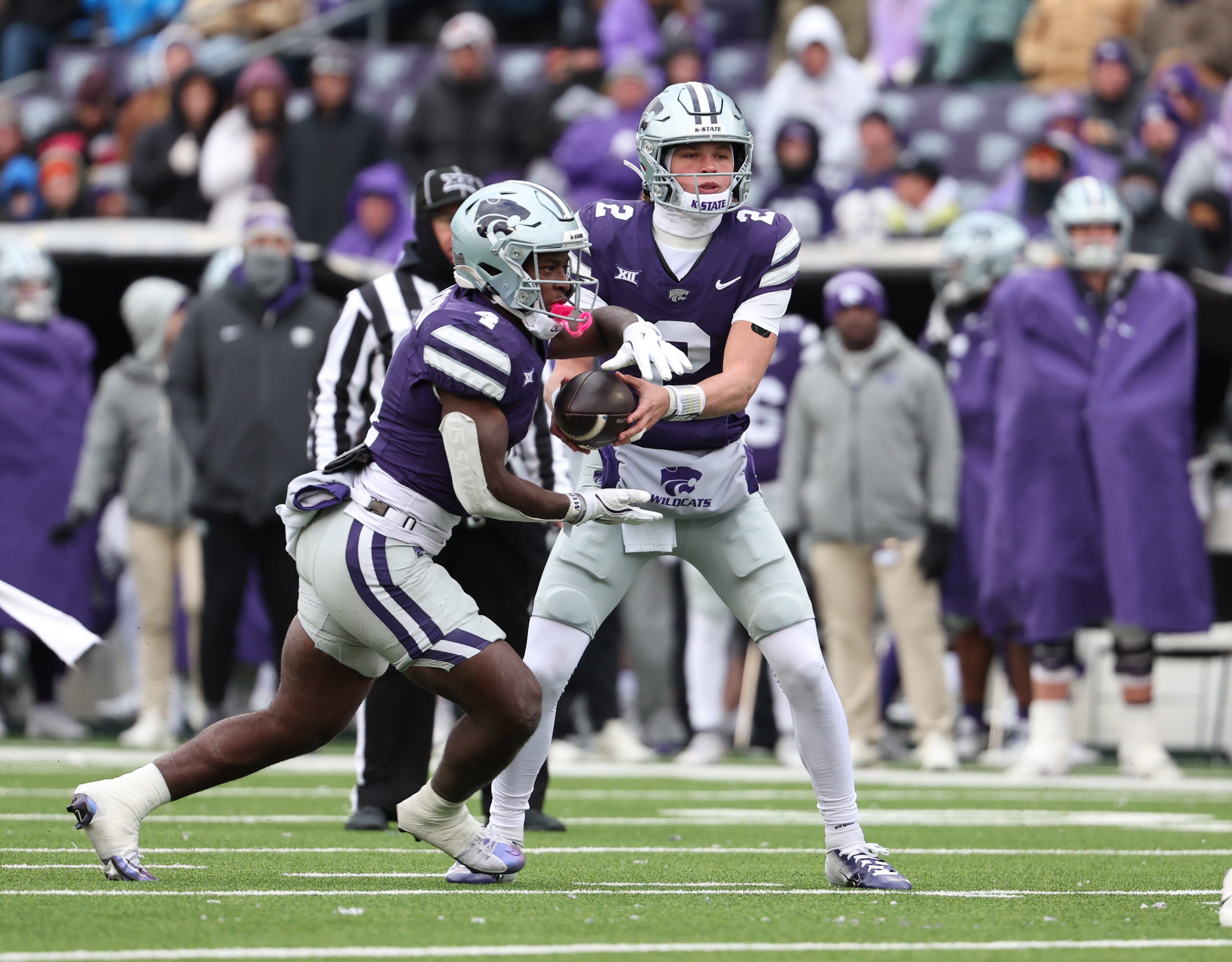 Nov 29, 2025; Manhattan, Kansas, USA; Kansas State Wildcats running back Joe Jackson (4) takes the handoff from quarterback Avery Johnson (2) during the fourth quarter at Bill Snyder Family Football Stadium. Mandatory Credit: Scott Sewell-Imagn Images