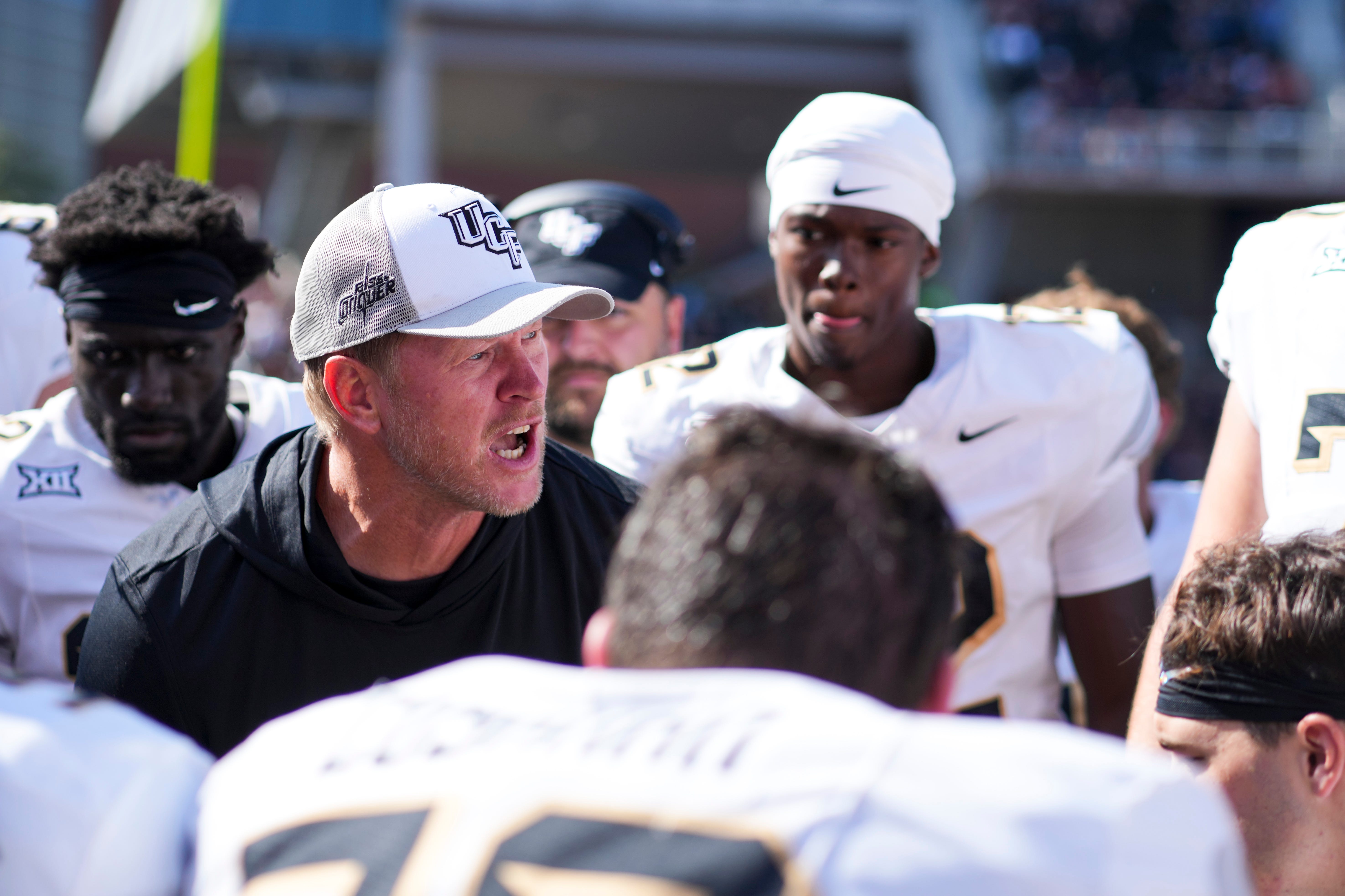 Oct 11, 2025; Cincinnati, Ohio, USA; UCF Knights head coach Scott Frost talks with his team on the sidelines in the game against the Cincinnati Bearcats in the second half at Nippert Stadium. Mandatory Credit: Aaron Doster-Imagn Images