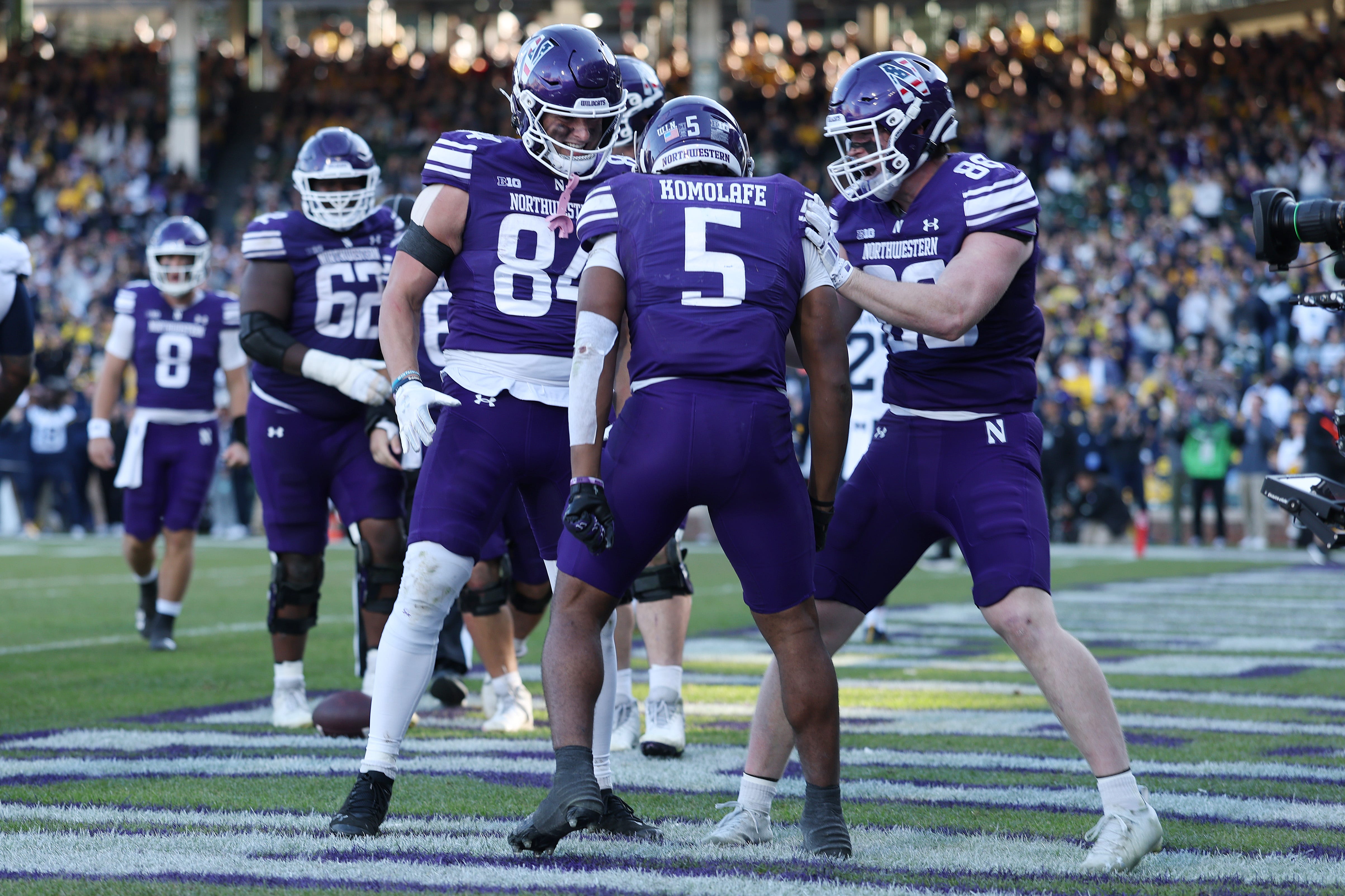 CHICAGO, ILLINOIS - NOVEMBER 15: Caleb Komolafe #5 of the Northwestern Wildcats celebrates a touchdown with teammates against the Michigan Wolverines during the second half at Wrigley Field on November 15, 2025 in Chicago, Illinois. (Photo by Michael Reaves/Getty Images)