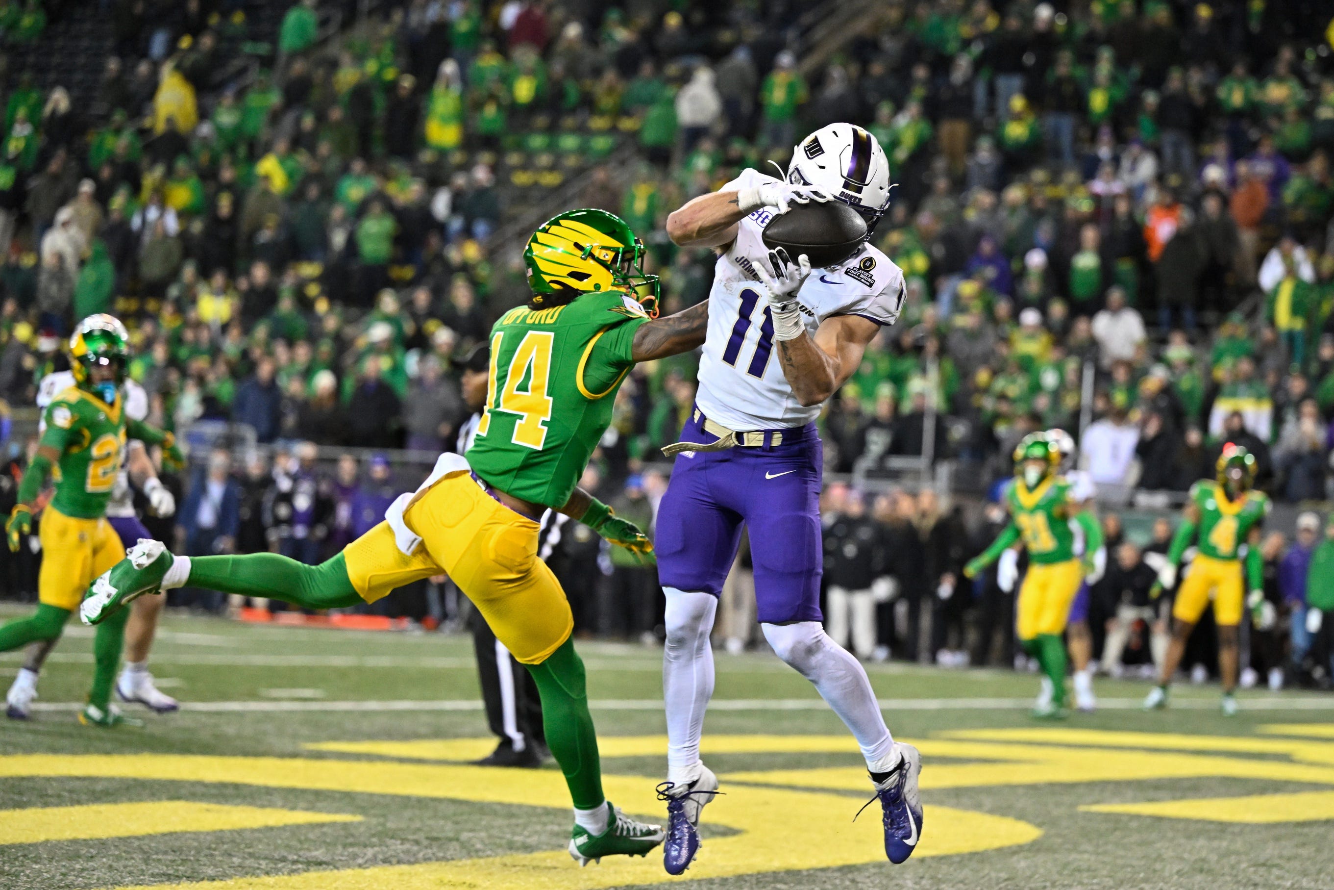 Dec 20, 2025; Eugene, OR, USA; James Madison Dukes wide receiver Nick Degennaro (11) makes a catch for a touchdown as Oregon Ducks defensive back Na'Eem Offord (14) defends during the fourth quarter at Autzen Stadium. Mandatory Credit: Craig Strobeck-Imagn Images