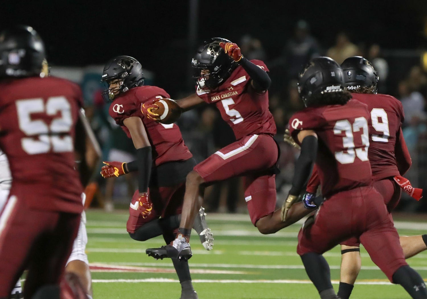 Oaks Christian's Davon Benjamin leaps through an opening after making an interception of a St. Bonaventure pass during the third quarter of the Marmonte League title game, Oct. 27, 2023, at Oak Christian's Thorson Stadium.