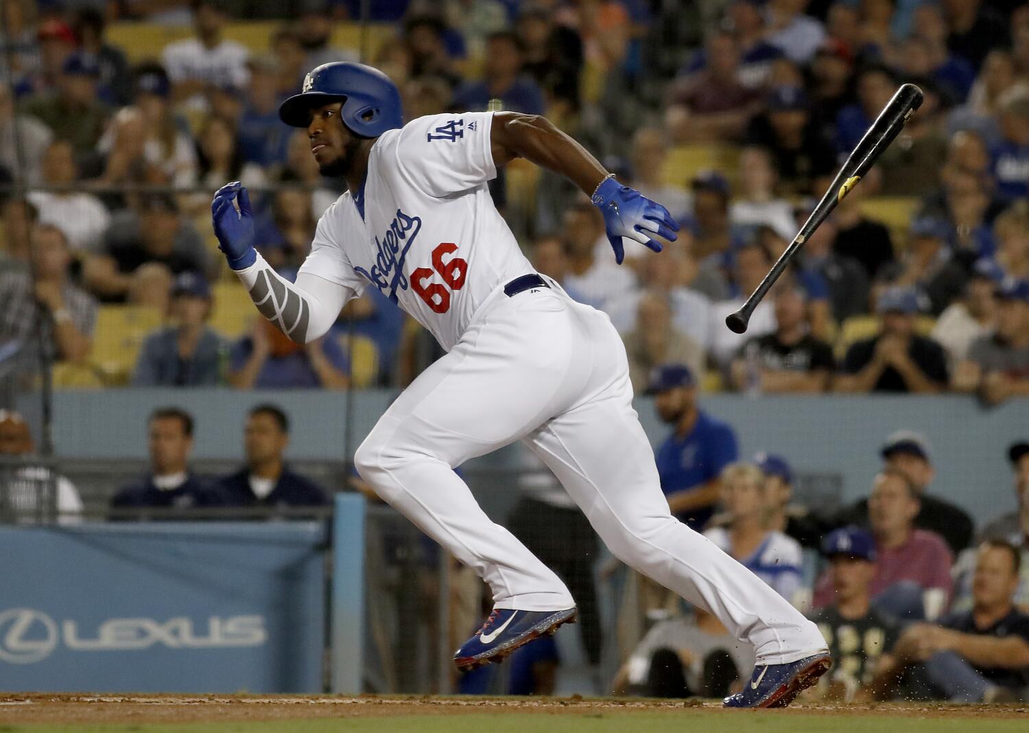Yasiel Puig running while wearing a blue batting helmet and in full Dodgers uniform
