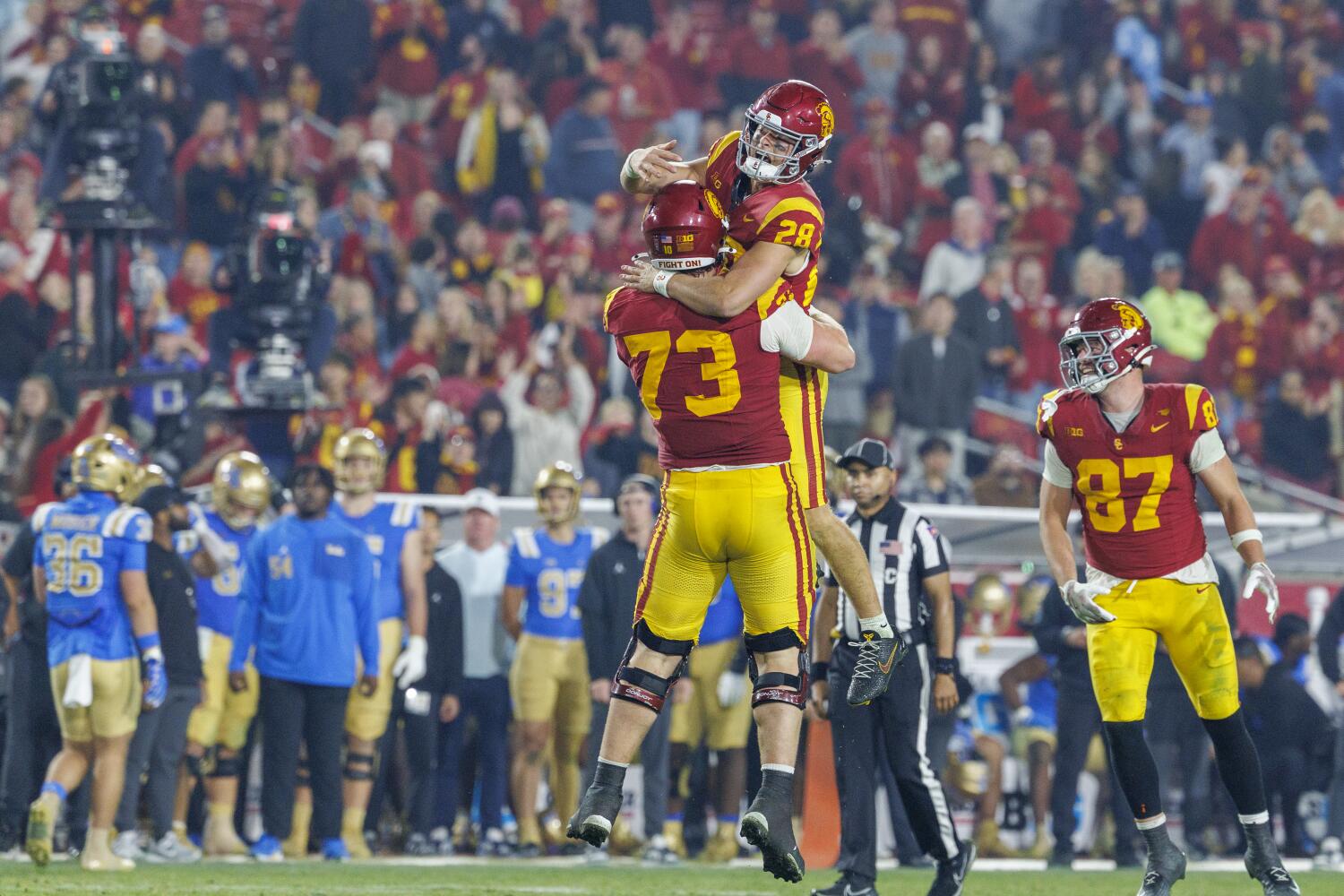 USC backup quarterback Gage Roy leaps into the arms of offensive lineman Tobias Raymond.