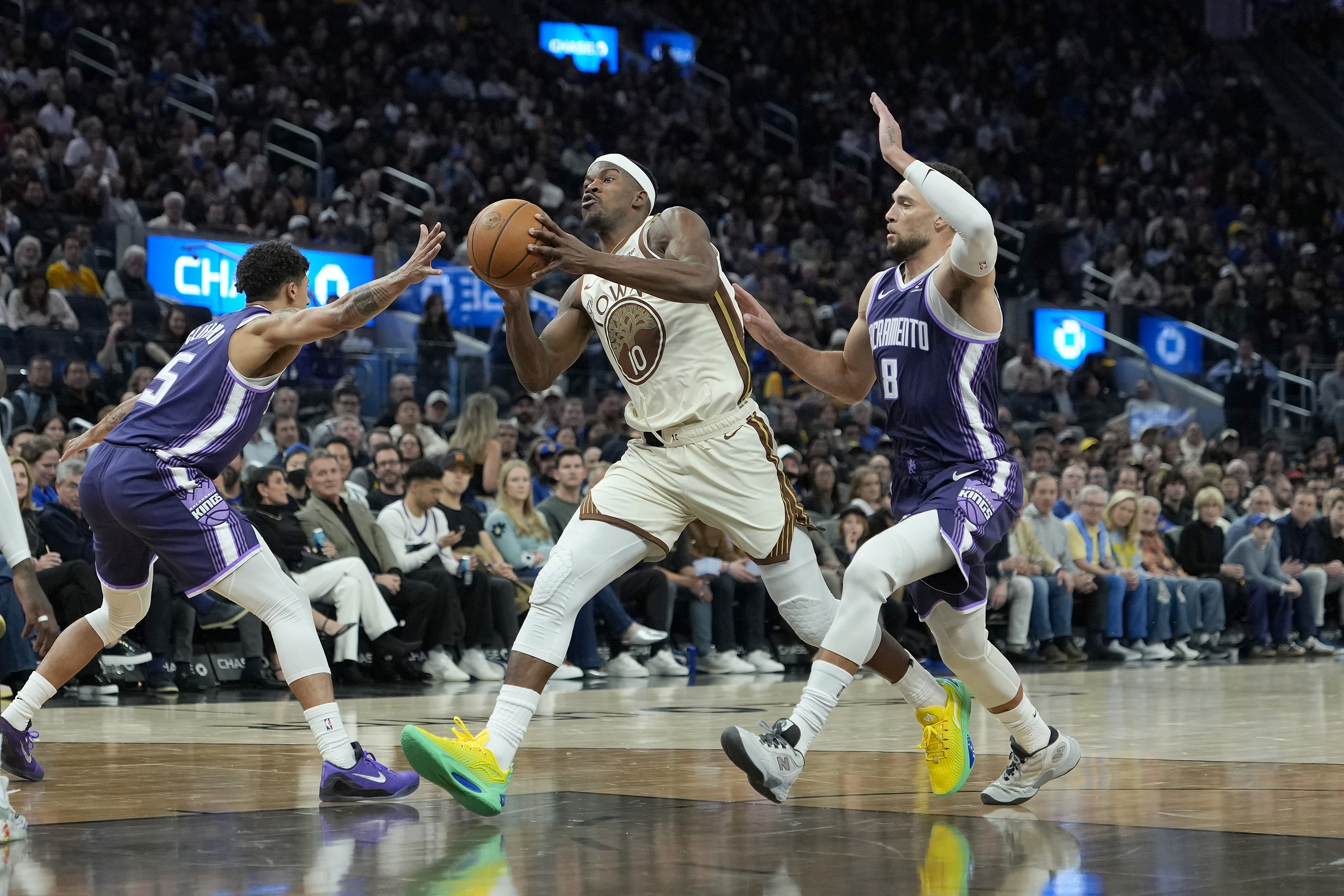 Golden State Warriors forward Jimmy Butler III drives past Sacramento Kings wing Zach LaVine.