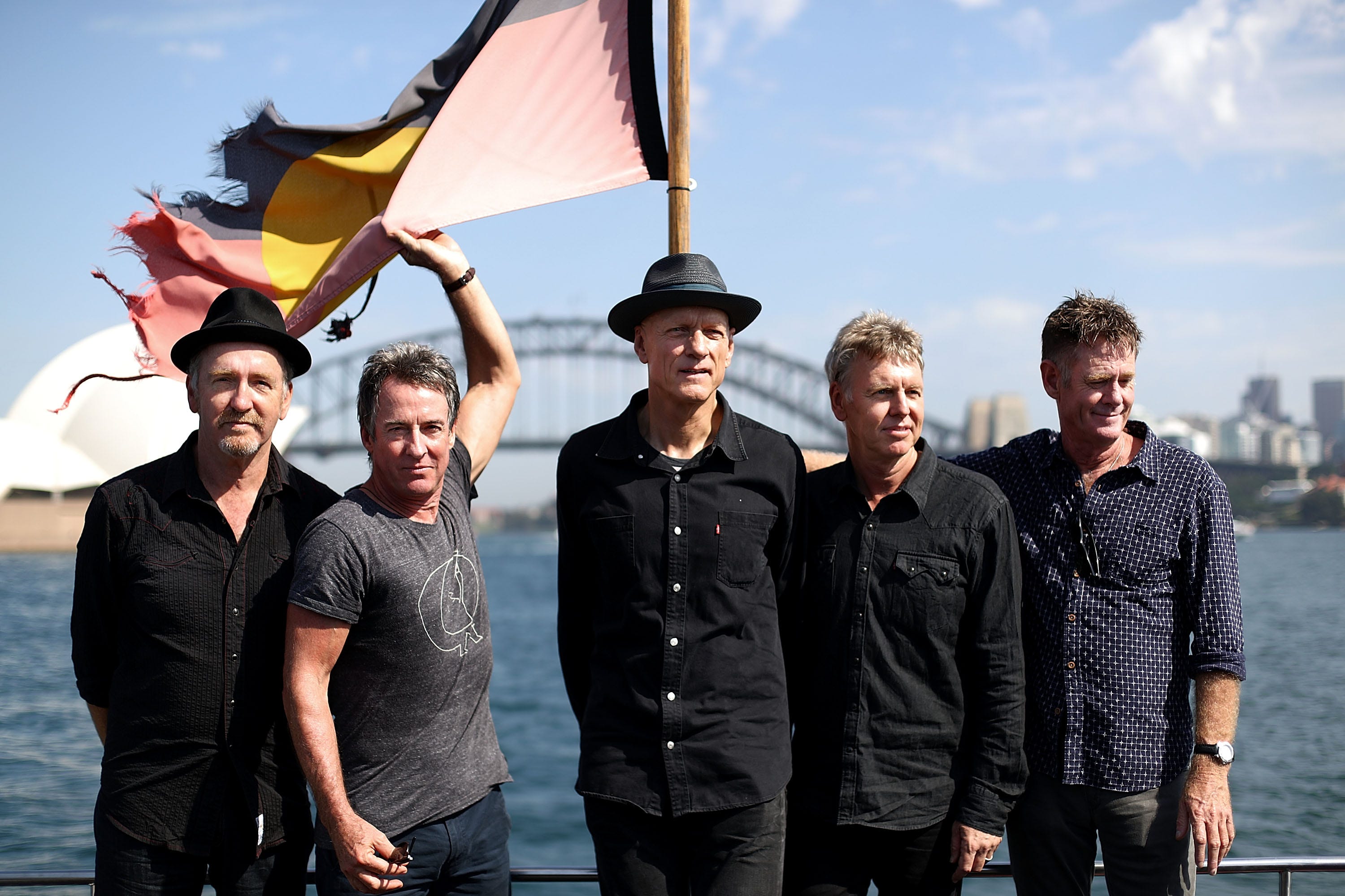 Midnight Oil members Bones Hillman, from left, Rob Hirst, Peter Garrett, Jim Moginie and Martin Rotsey pose on Sydney Harbour after announcing their world tour on Feb. 17, 2017.