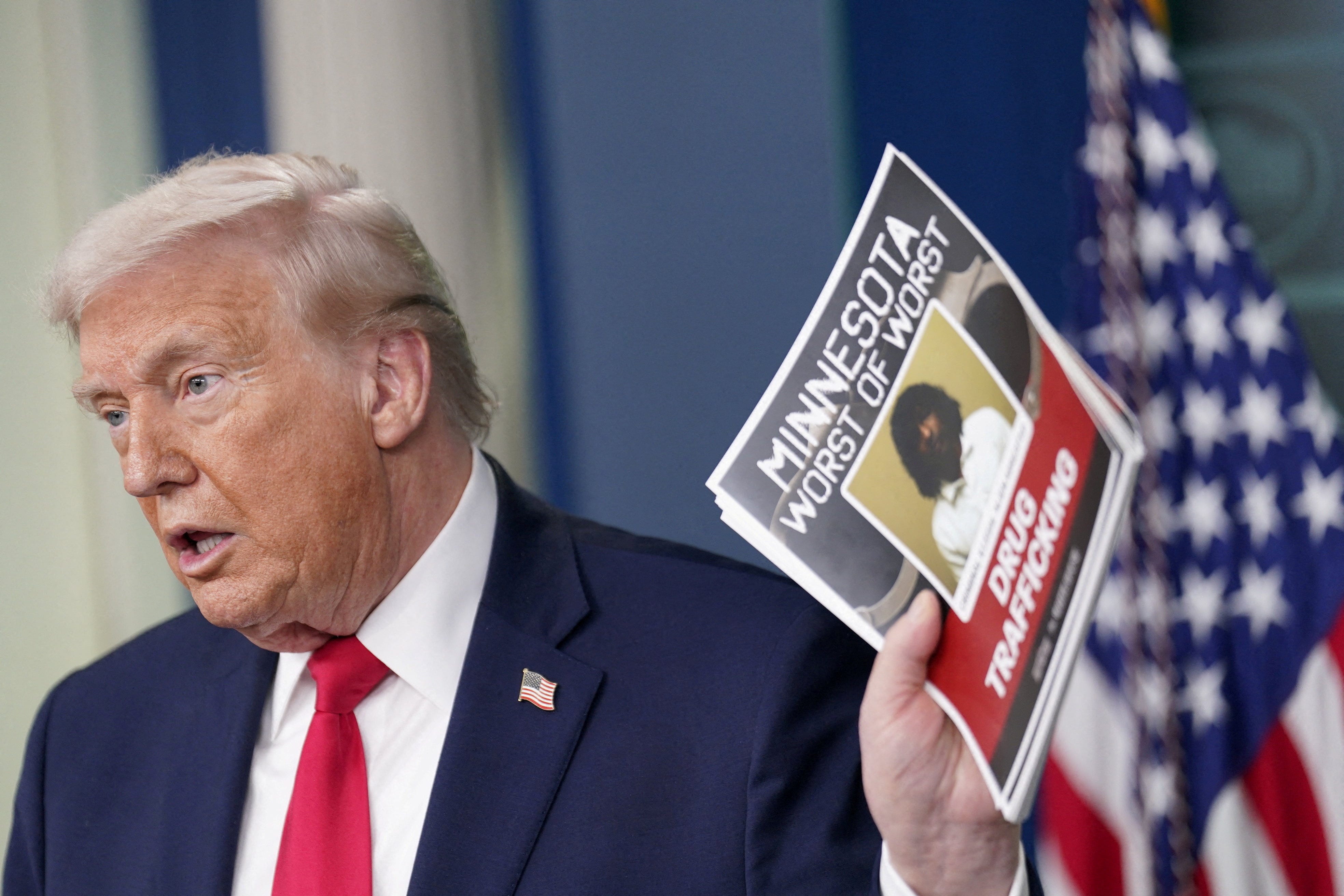 President Donald Trump holds a poster of an alleged criminal taken off of Minnesota streets by ICE during a press briefing at the White House, on the one-year mark into his second term in office, in Washington, D.C., U.S., January 20, 2026.