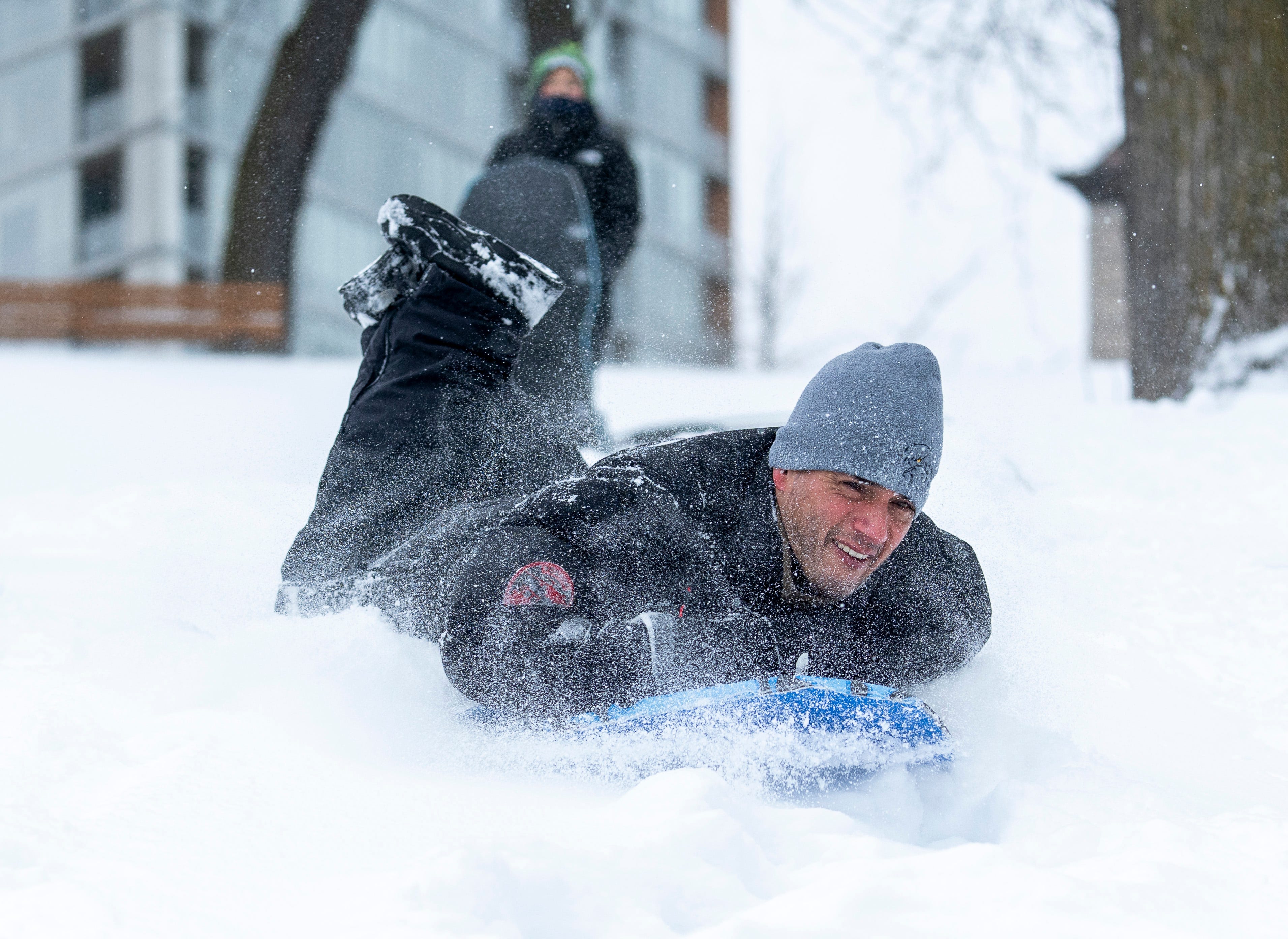 Maclovio Vega shows his 9-year-old son Maky Vega how to go down a hill with a sled at McKinley Park on Saturday Jan.17, 2026 in Milwaukee, Wisc.
