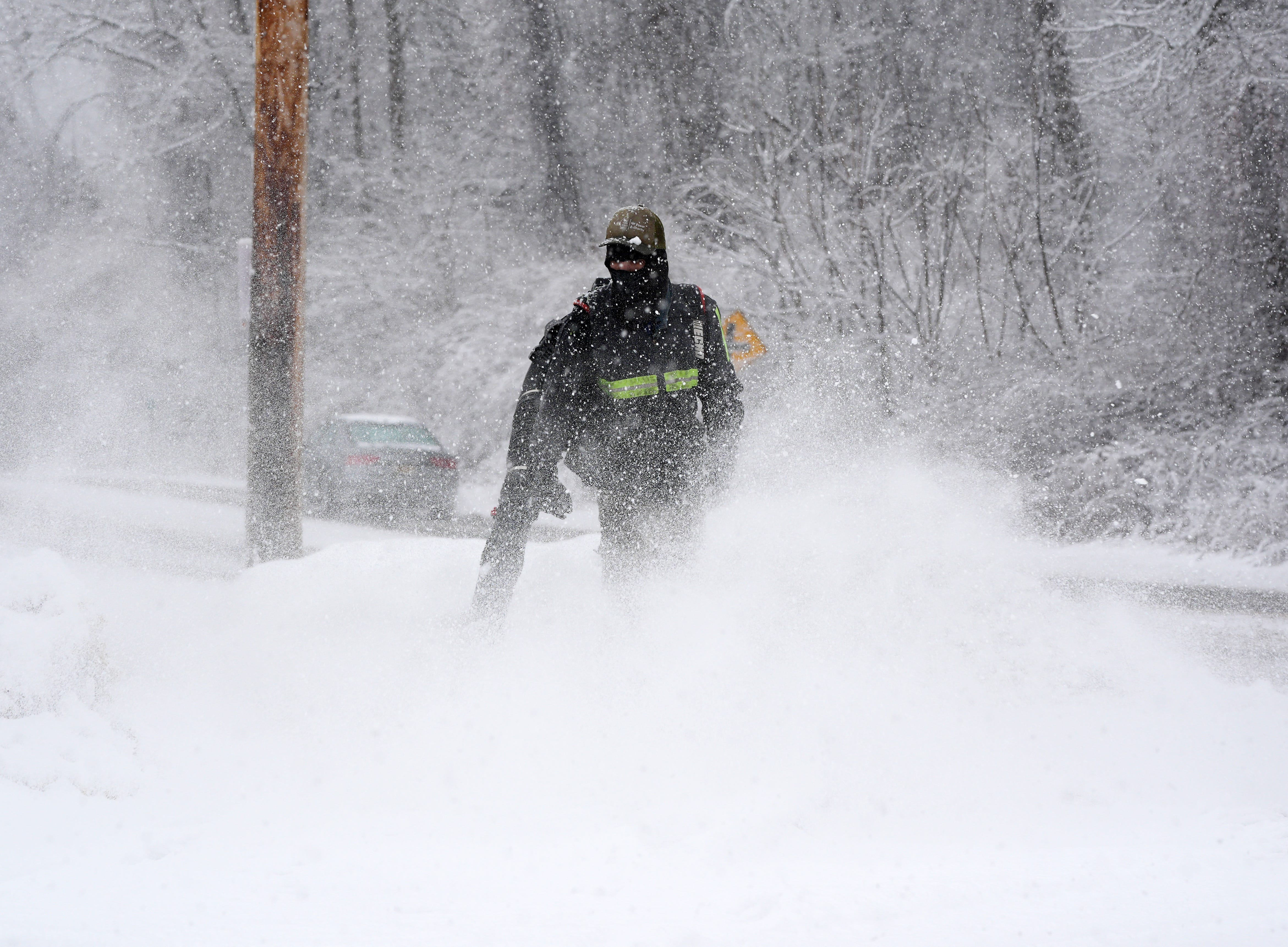 A worker uses a leaf blower to clear snow along Route 202 in Somers, NY on Jan. 17, 2026.
