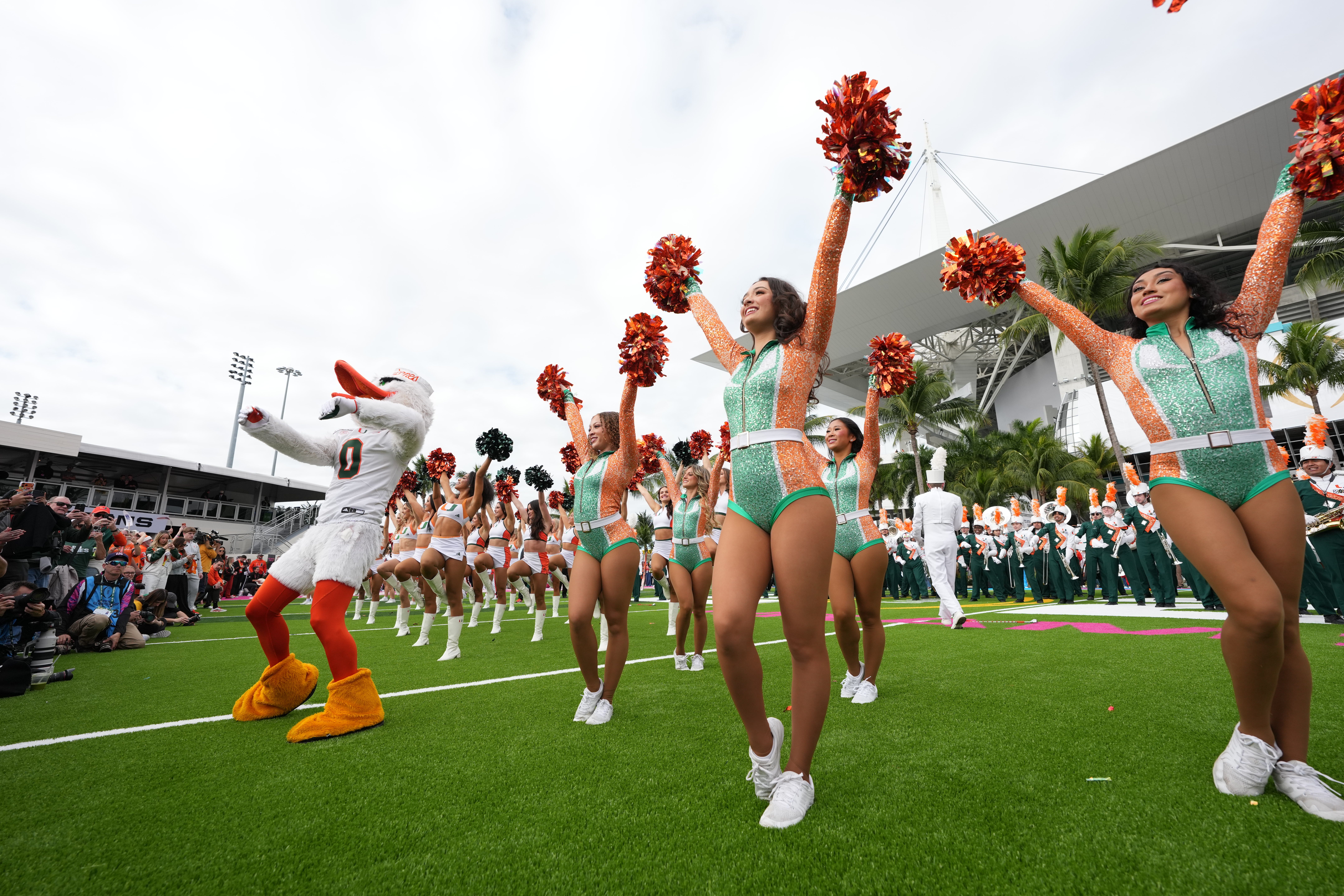 Miami Hurricanes mascot Sebastian poses with cheerleaders and marching band during the CFP National Championship college football game at Hard Rock Stadium.
