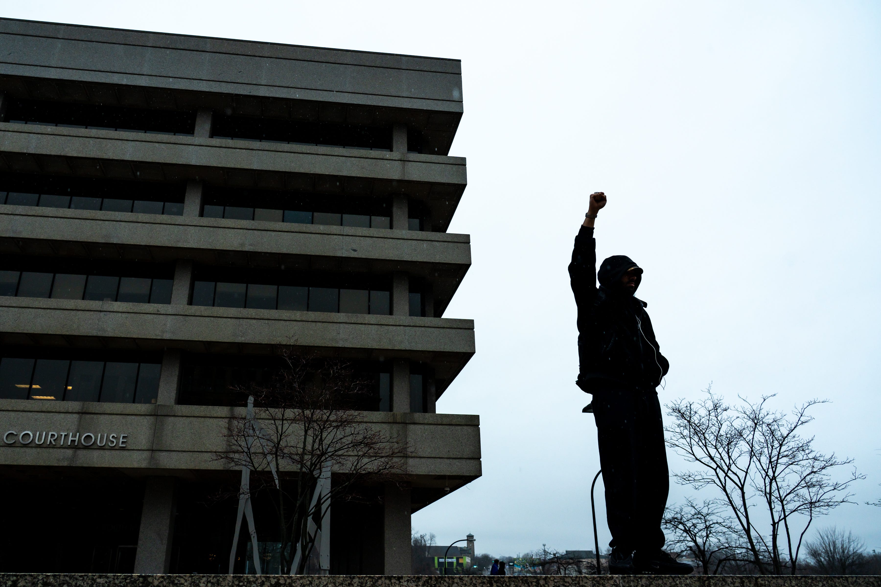 A man raises his first in solidarity during an ICE Out For Good protest Jan. 10, 2026, at the John F. Seiberling Federal Building and United States Courthouse in Akron, Ohio.