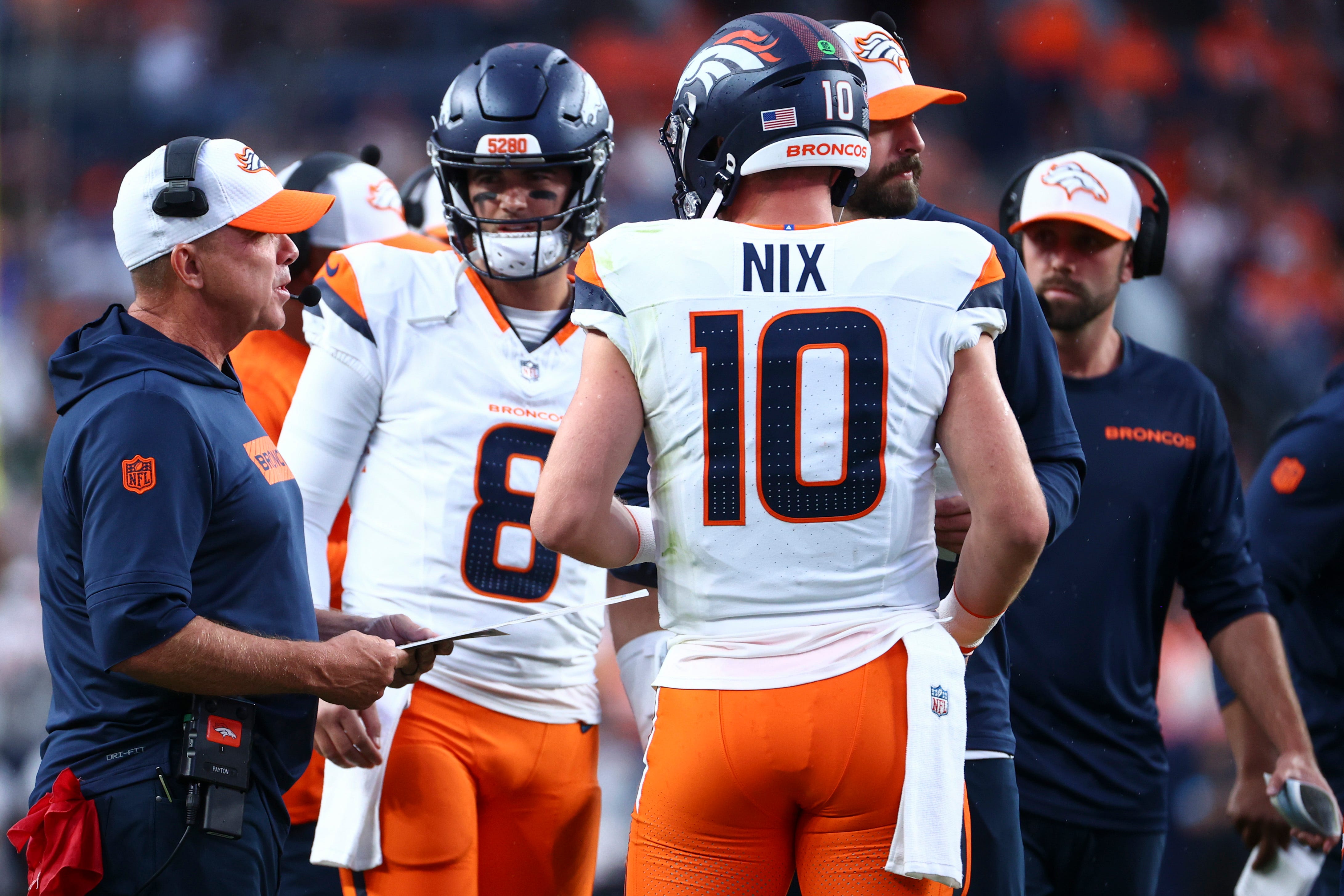 Broncos coach Sean Payton, left, talks with quarterbacks Jarrett Stidham (8) Bo Nix during the first half of a preseason game against the Packers at Empower Field At Mile High in Denver on Aug. 18, 2024.